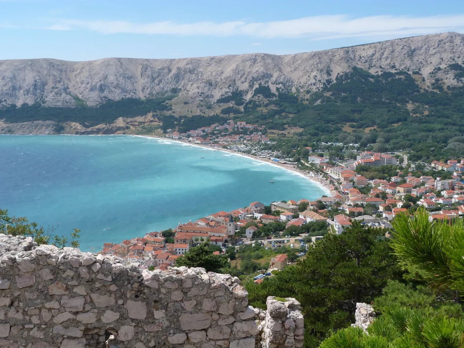 La baie de Baška sur l'île de Krk, plage en arc et montagnes arides