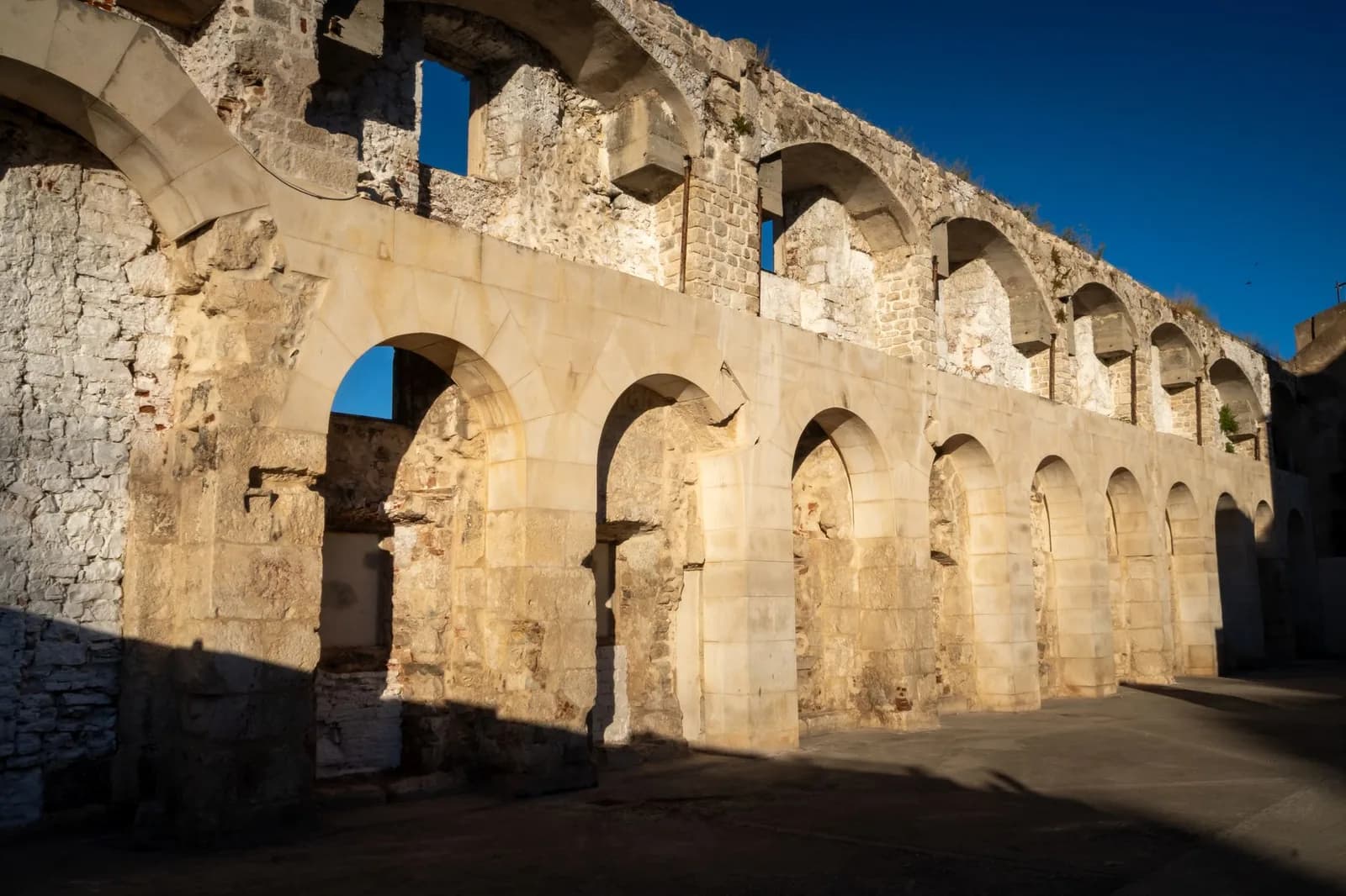 Grandes arcades de pierre antiques éclairées par le soleil, vestiges du palais de Dioclétien à Split