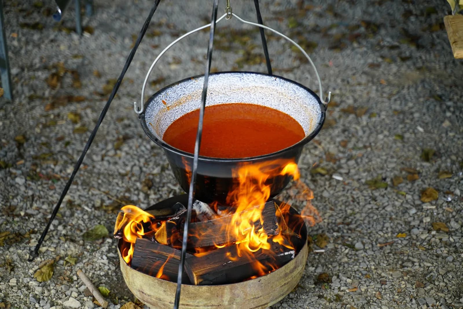 Un ragoût rouge qui mijote dans un chaudron suspendu au-dessus du feu