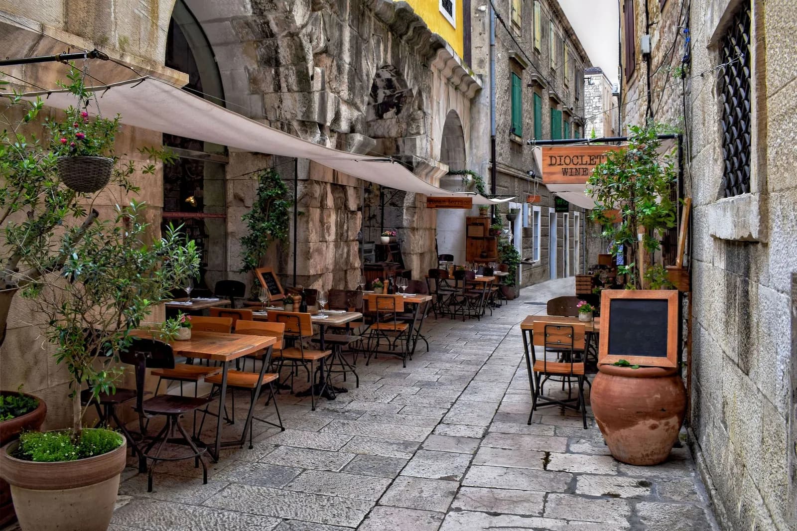 La terrasse d'une konoba dans une ruelle de pierre en Dalmatie