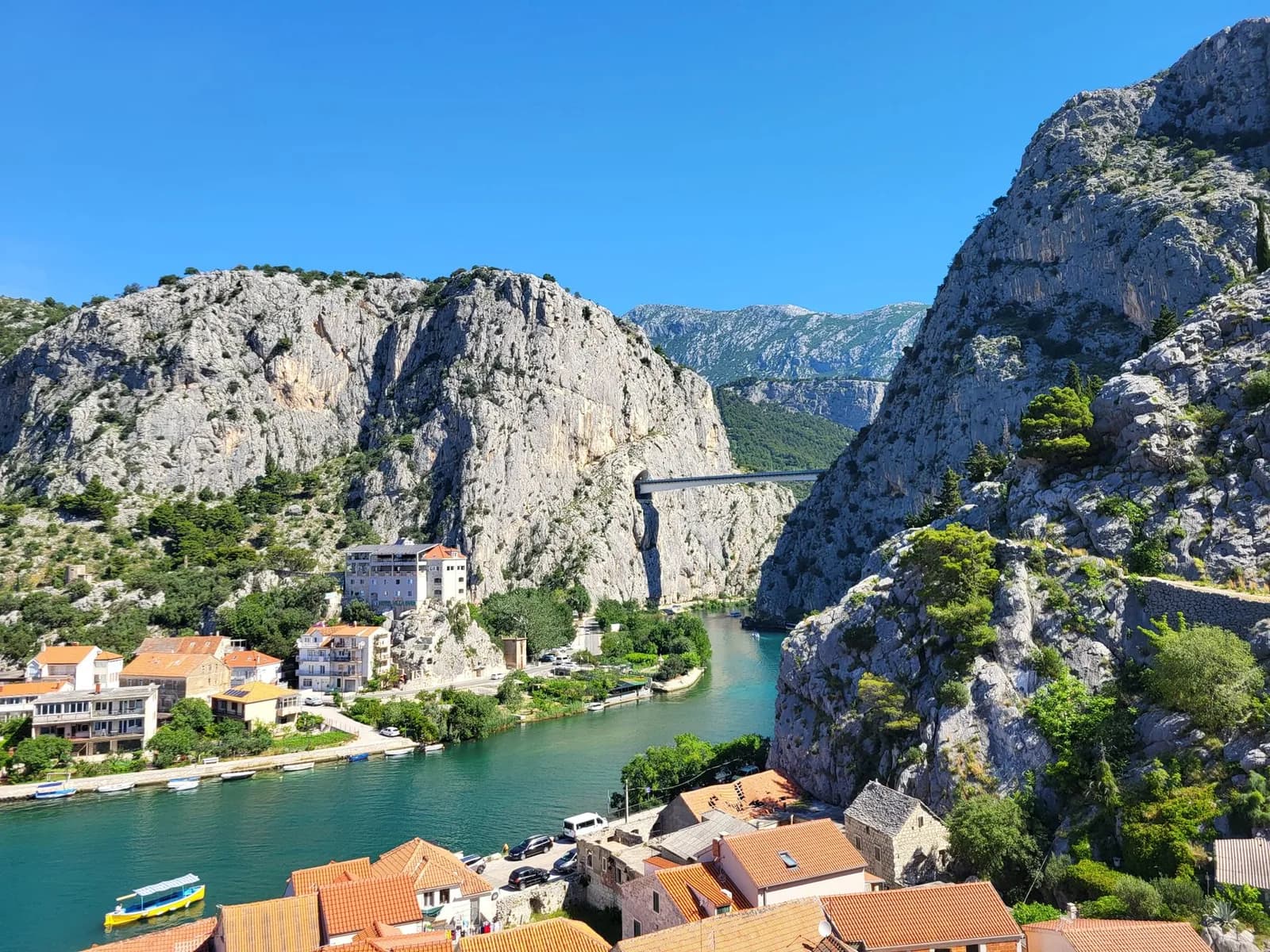 Vue d'Omiš depuis les hauteurs : toits en tuiles orange, rivière Cetina turquoise et falaises du canyon