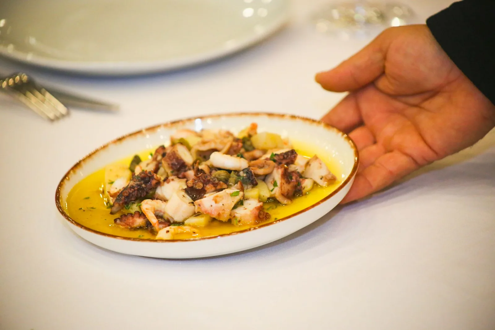 Une salade de poulpe à l'huile d'olive dans un plat ovale