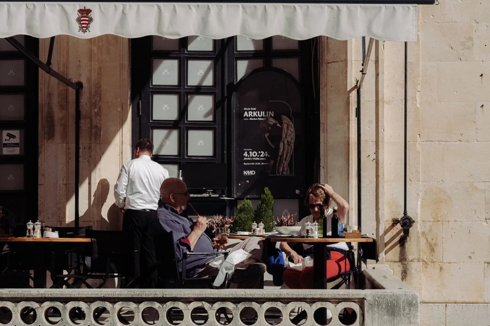 Serveur et convives sur la terrasse d'un restaurant de la vieille ville de Dubrovnik