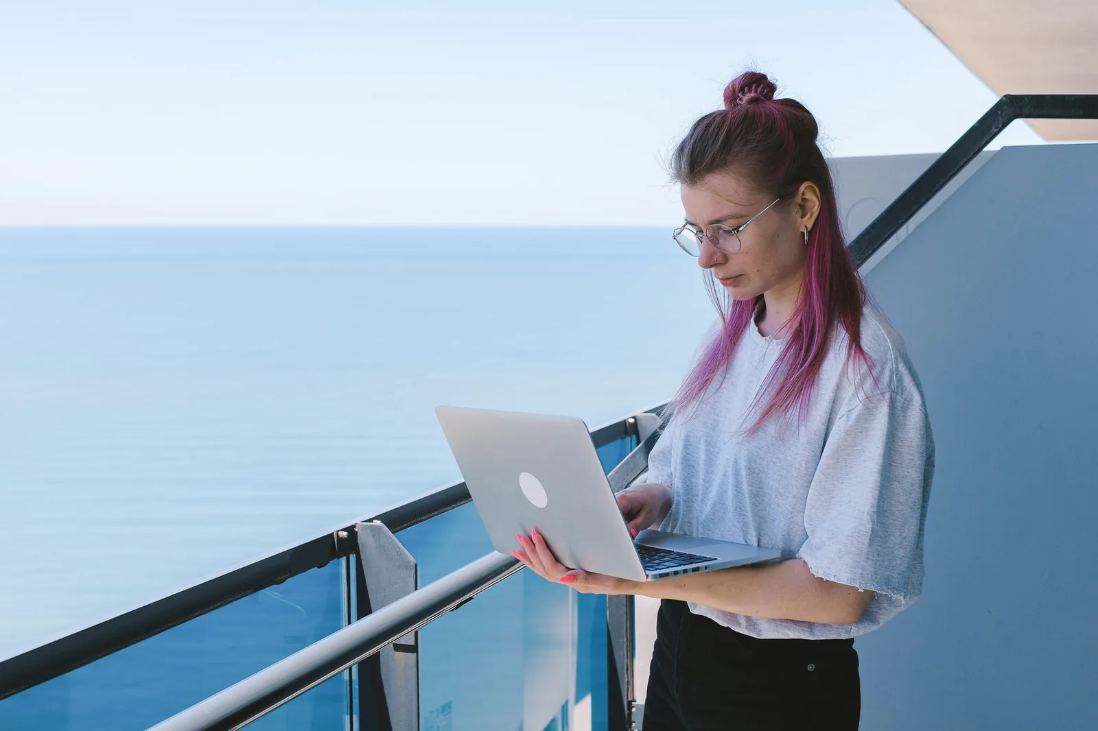Personne travaillant sur un ordinateur portable face à la mer