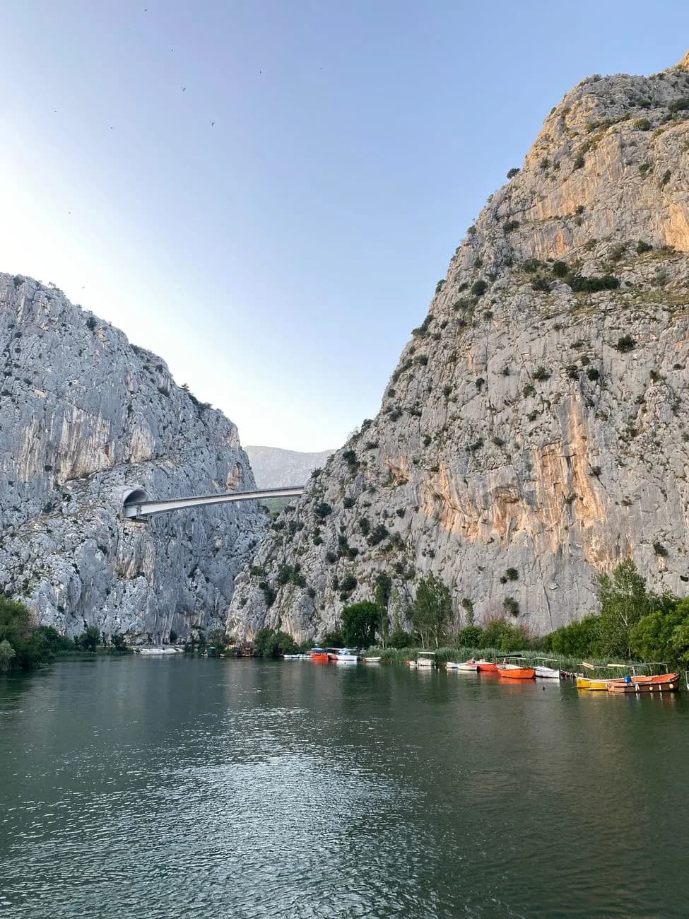 Canyon de la Cetina à Omiš vu depuis la rivière, avec ses parois rocheuses et le pont au loin