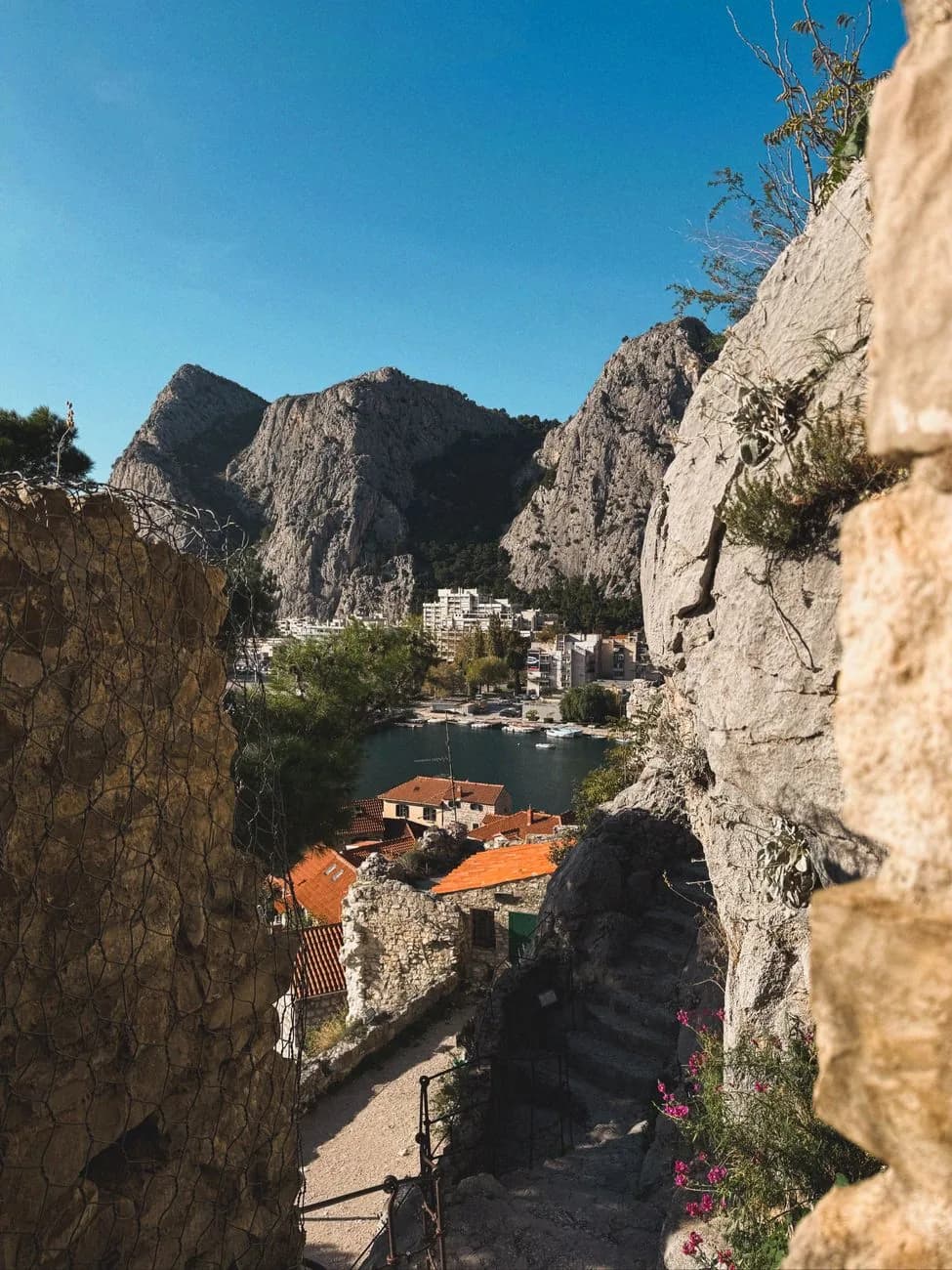 Escalier de pierre entre deux parois rocheuses menant vers les toits de la vieille ville d'Omiš