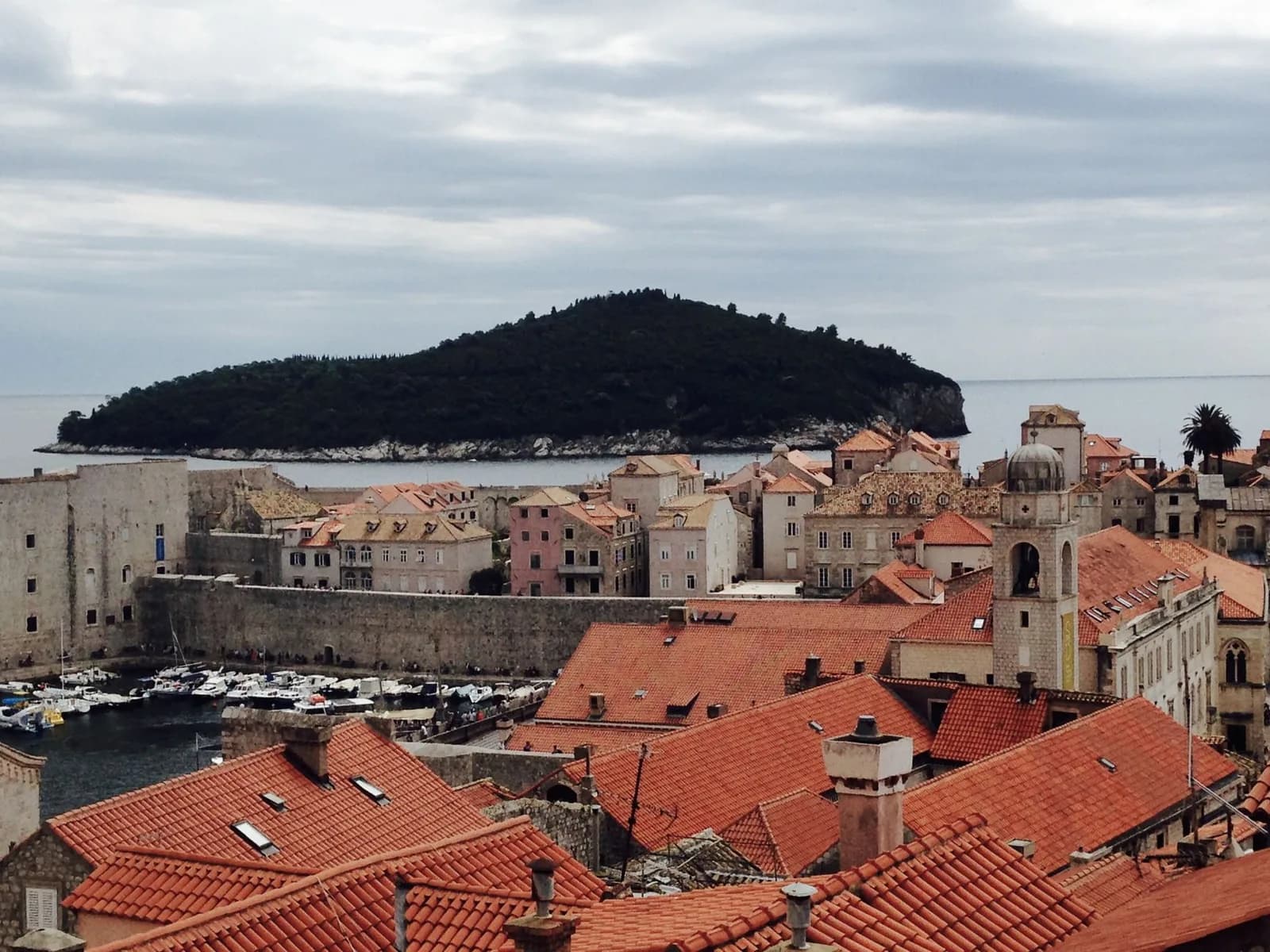 Le vieux port de Dubrovnik et l'île boisée de Lokrum vus depuis les remparts