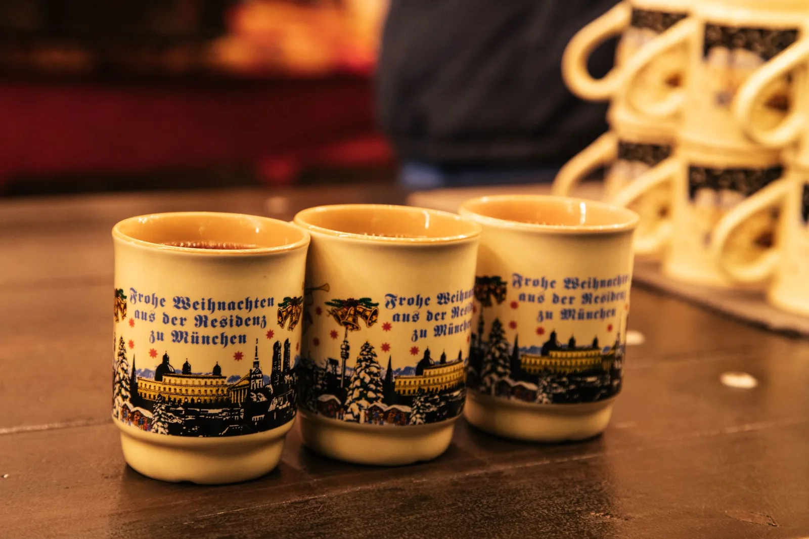 Petits mugs de vin chaud posés sur l'étal d'un marché de Noël